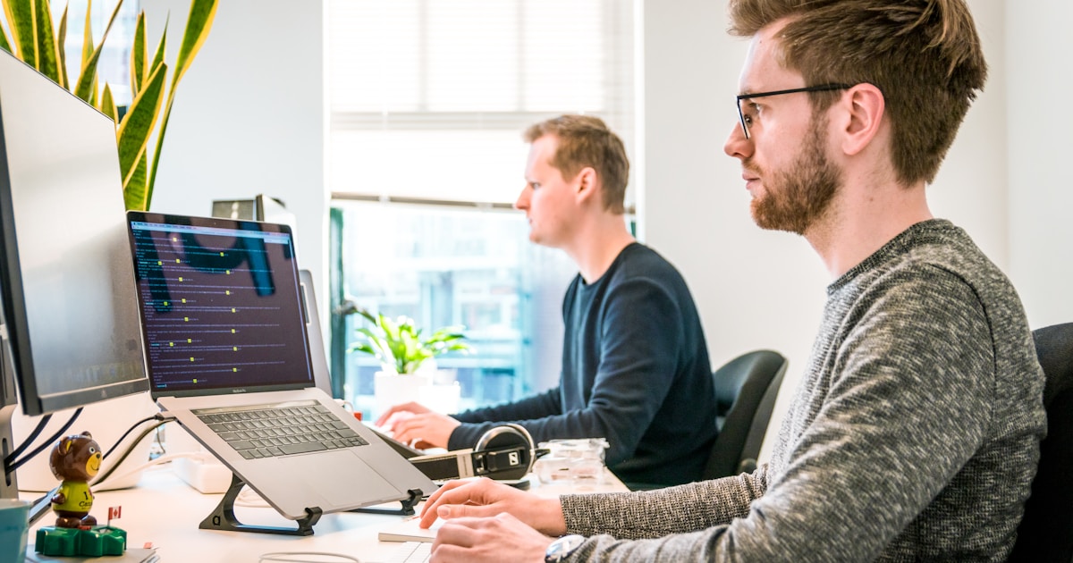 Developer working on workflow automation at desk with multiple monitors